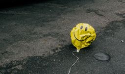 A balloon on the floor, looking a bit rough.