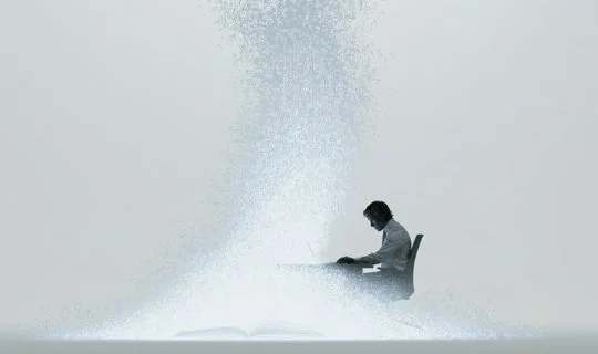 A man sitting at a desk with code rising up