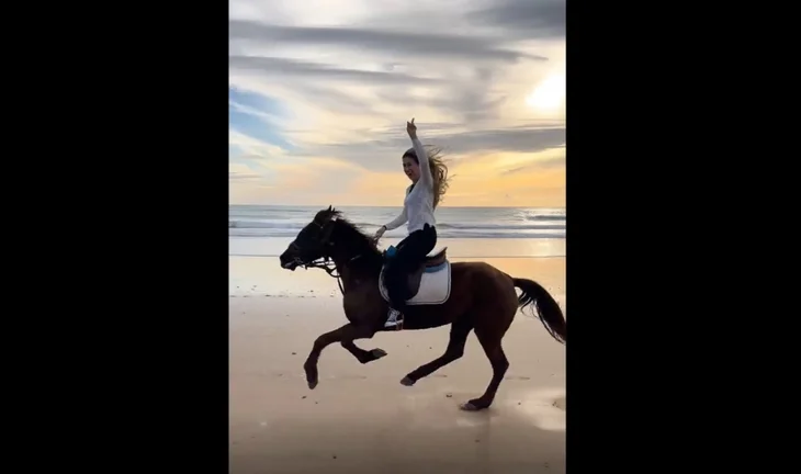 Woman riding horse on the beach