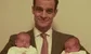a man holding two babies 